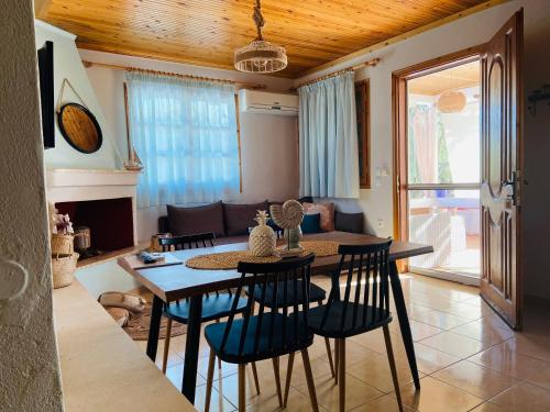 ein Wohnzimmer mit einem Tisch, Stühlen und einem Sofa in der Unterkunft Dream house Villa in Aliki