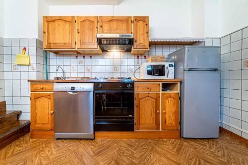 una cucina con armadietti in legno ed elettrodomestici in acciaio inossidabile di Al Cesaril ad Alleghe