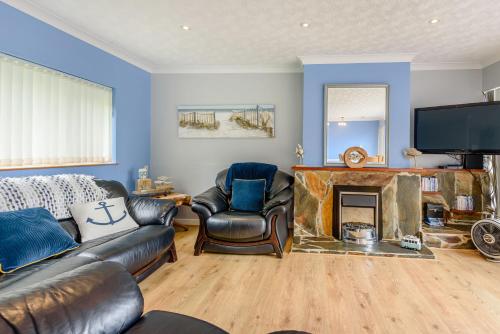 a living room with a couch and a fireplace at 17 Glyn Y Marian in Llanbedrog