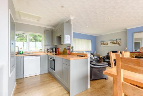 a kitchen with blue walls and white cabinets at 17 Glyn Y Marian in Llanbedrog