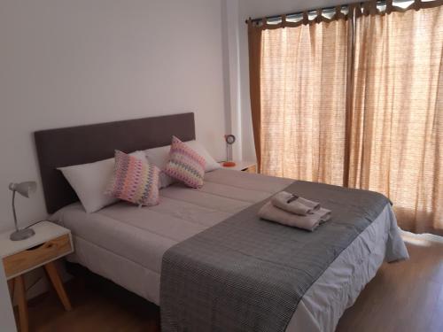 a bedroom with a large bed with pink pillows at BELGRANO LUMINOSO Y AMPLIO DEPARTAMENTO in Buenos Aires