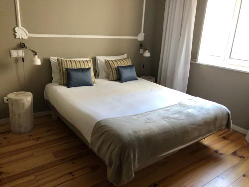 a bedroom with a large bed with blue pillows at Godinho's House in Matosinhos