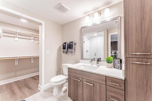 a bathroom with a toilet and a sink and a mirror at Upscale Modern Apts - Free Parking, Fast WiFi, Courtyard in Austin