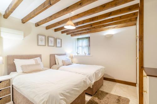 2 camas en una habitación con techos de madera en Lanes Barn en Glaisdale