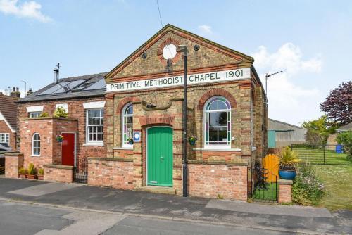 a brick building with a green door on a street at The New Chapel in Goxhill