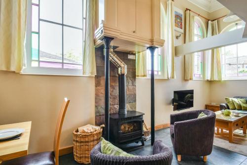 a living room with a wood stove and chairs at The New Chapel in Goxhill