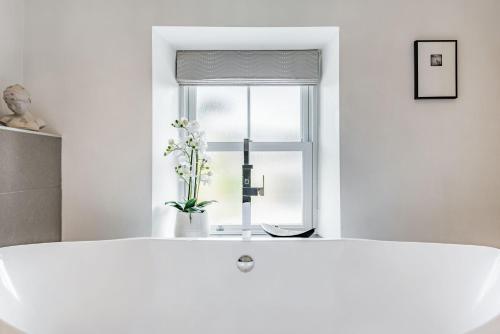 a white bath tub in front of a window at 2 Bryn Tirion in Tanygrisiau