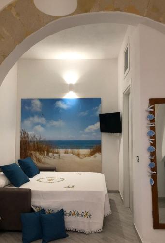 a bedroom with a bed and a painting of the beach at A Petrazzi in Castellammare del Golfo