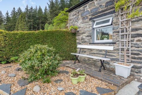 a bench sitting next to a building with a window at Henrhiw Bach in Dolwyddelan