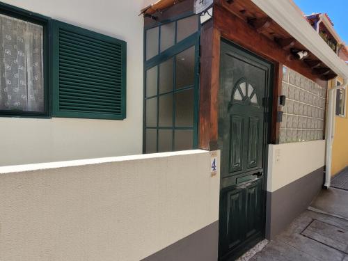 uma porta verde do lado de um edifício em Casa Alegria no Funchal