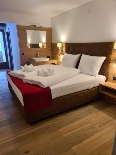 a bedroom with a large bed with a red blanket at Hotel Alpenhof*** in Kaltenbach