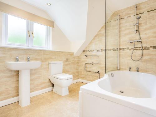 a bathroom with a sink and a toilet and a bath tub at Beeches Studio in Great Witcombe