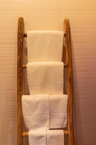 a stack of towels on a towel rack in a bathroom at Casas de Campo do Castro da Cola in Marchicão