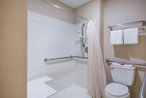 a bathroom with a shower and a toilet at SureStay Hotel by Best Western Rockdale in Rockdale