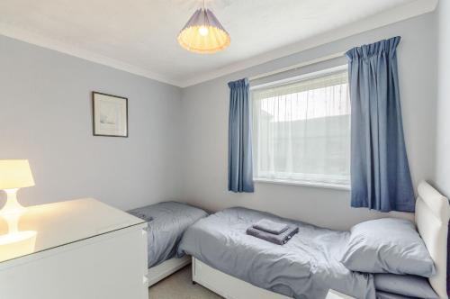 a bedroom with two beds and a desk and a window at Beefs Park Farm Annexe in Carmarthen