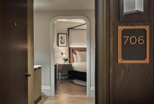 a hotel room with a bed and a door with a sign at Pendry Washington DC - The Wharf in Washington