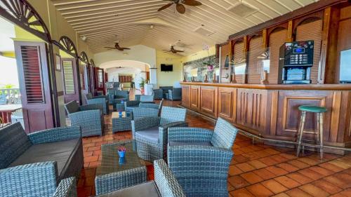 a restaurant with blue chairs and a bar at Hotel Auberge de la Vieille Tour in Le Gosier