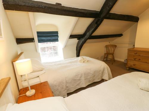a bedroom with two beds and a window at 89 High Street in Kirkby Stephen