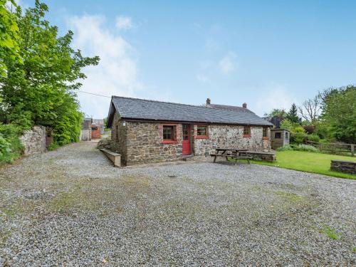 a stone cottage with a picnic table in front of it at Cilwen Fach in Abernant