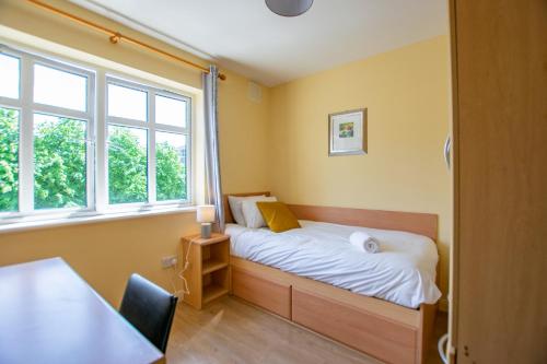 a small bedroom with a bed and a window at 137 - The Townhouse at Gort Na Coiribe By Shortstays in Galway
