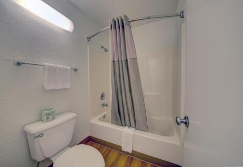 a white bathroom with a shower and a toilet at Motel 6-Cocoa Beach, FL in Cocoa Beach