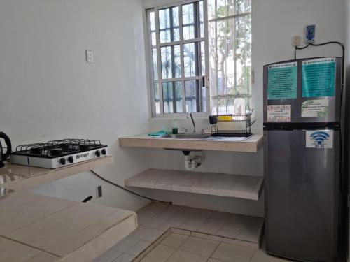 a kitchen with a stove and a sink and a refrigerator at Viento Casa los 4 elementos in Cancún