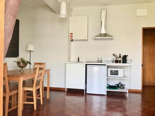 uma cozinha e sala de jantar com uma mesa e um micro-ondas em Boavista YourHome no Porto