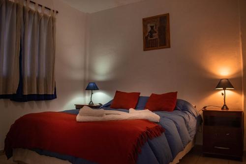 a bedroom with a bed with red and blue at Cabañas Valles Calchaquíes in Santa María