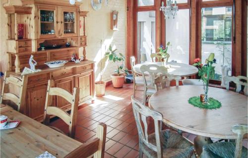 eine Küche mit einem Tisch und Stühlen sowie einem Tisch und einem Tisch mit einem Stuhl in der Unterkunft Nice Home In Petershagen Ot Frille With Kitchen in Frille