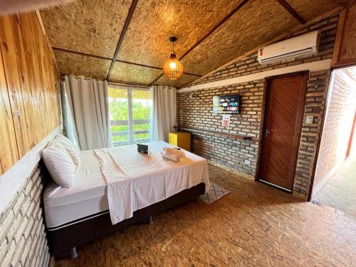 a bedroom with a bed in a brick wall at Villa Flecheiras in Flecheiras