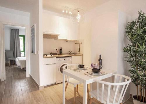 a white kitchen with a table and chairs in a room at Holyhome premium 106 in Costa Teguise