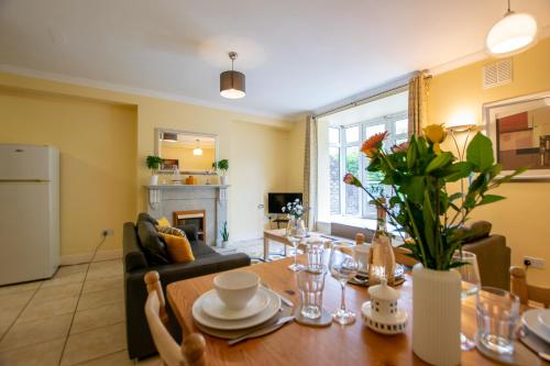 a living room with a wooden table with flowers on it at 126 - Gort Na Coiribe 4 Bedroom Duplex, by Shortstays in Galway