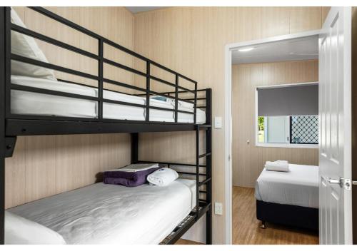 a bunk bed room with two bunk beds and a mirror at Discovery Parks - Mackay in Mackay