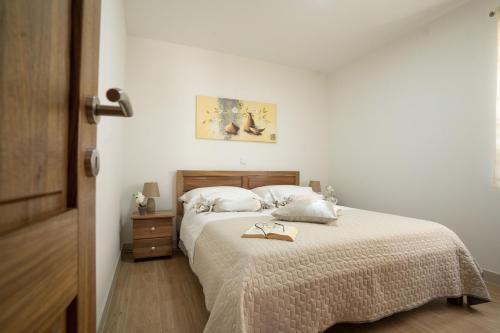 a bedroom with a bed with a pair of glasses on it at Villa Kalinić in Milna
