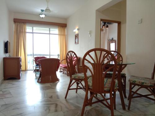 a dining room with chairs and a table and a window at Glory beach resort private apartment in Port Dickson