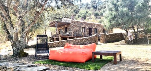 a couch sitting on the grass in front of a house at Casas de Campo do Castro da Cola in Marchicão