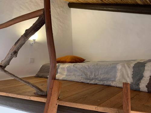 a bedroom with a bed and a wooden floor at Casas de Campo do Castro da Cola in Marchicão