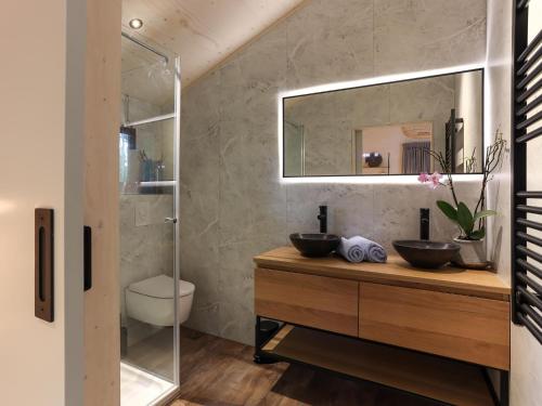 a bathroom with two sinks and a mirror at Welcoming holiday home in Wissenkerke with private sauna in Wissenkerke