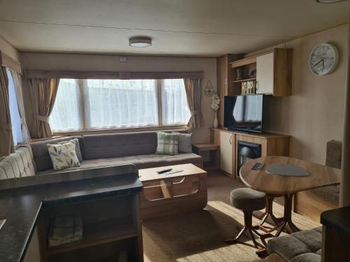 a living room with a couch and a table at 8 Berth blow heated on Sealands New Horizon in Ingoldmells