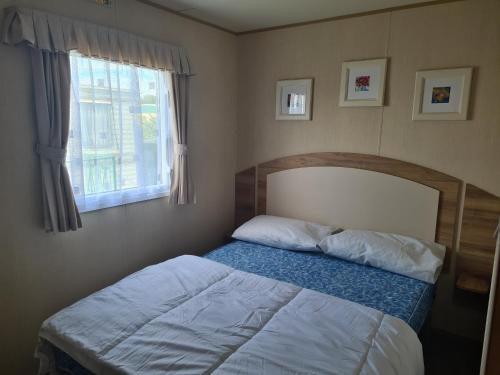 a bedroom with a bed and a window at 8 Berth blow heated on Sealands New Horizon in Ingoldmells