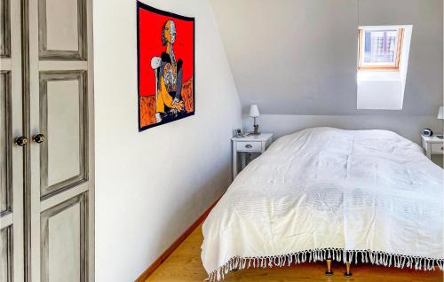 イースタッドにあるAwesome Home In Ystad With 1 Bedrooms And Wifiのベッドルーム1室(ベッド1台付)が備わります。壁には絵画が飾られています。