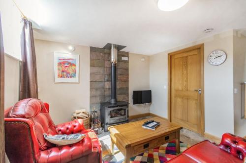 a living room with a red chair and a wood stove at The Old Chapel in Goxhill
