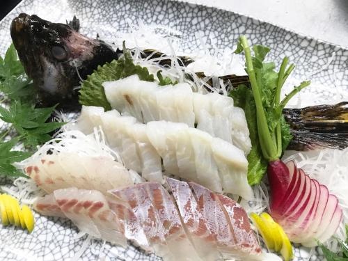 a plate of food with fish and vegetables on it at Shodoshima Olive Youth Hostel in Shodoshima
