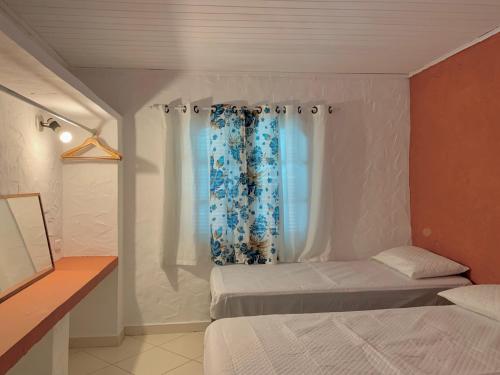 a bedroom with two beds and a window at Waimea Flats Maresias in Maresias