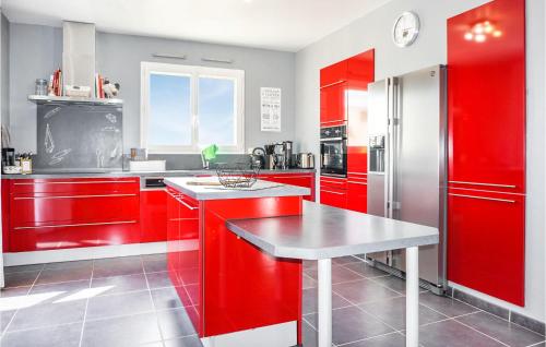 a kitchen with red cabinets and a table in it at Lovely Home In Cruzy With Kitchen in Cruzy