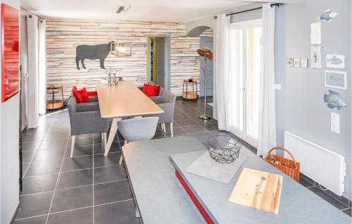 a dining room with a table and a cow on the wall at Lovely Home In Cruzy With Kitchen in Cruzy