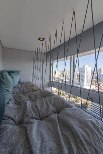 a bed in a room with a large window at Urban Sky Studio - GRU 2204 in Guarulhos