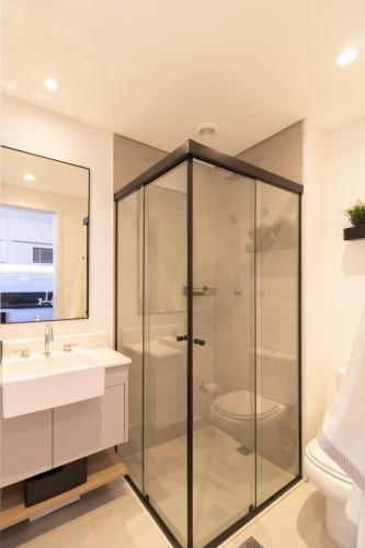 a bathroom with a glass shower and a sink at Urban Sky Studio - GRU 2204 in Guarulhos