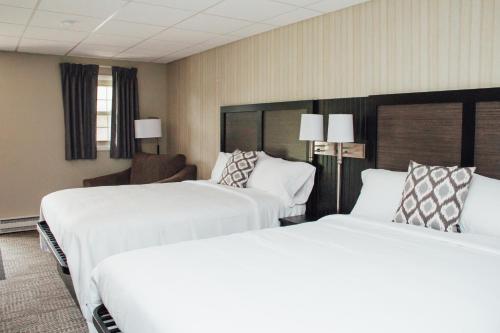 Ένα ή περισσότερα κρεβάτια σε δωμάτιο στο Country Squire Inn and Suites