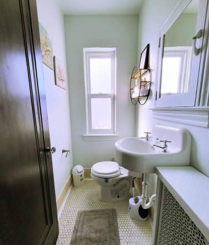 Baño blanco con lavabo y aseo en Vintage Charm, E. Eng. Village, 10mins to Dt. Det. en Detroit
